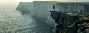 a lone adventurer standing at the edge of a majestic cliff, gazing out at uncharted lands waiting to be explored.